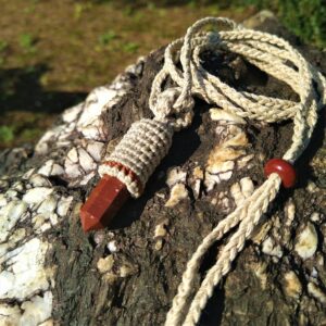 Handmade crystal point necklace on a stone. Earthy jewelry with red jasper.