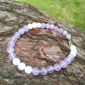 Amethyst and white jade beaded bracelet on wood. Handmade jewelry, gemstone bracelet.